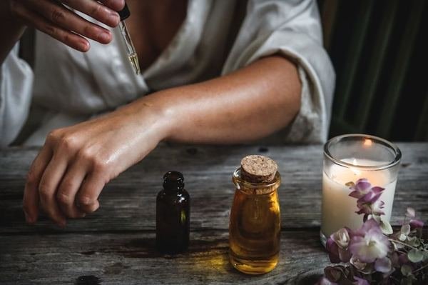 Practitioner in white kurta holding fresh Ayurvedic herbs